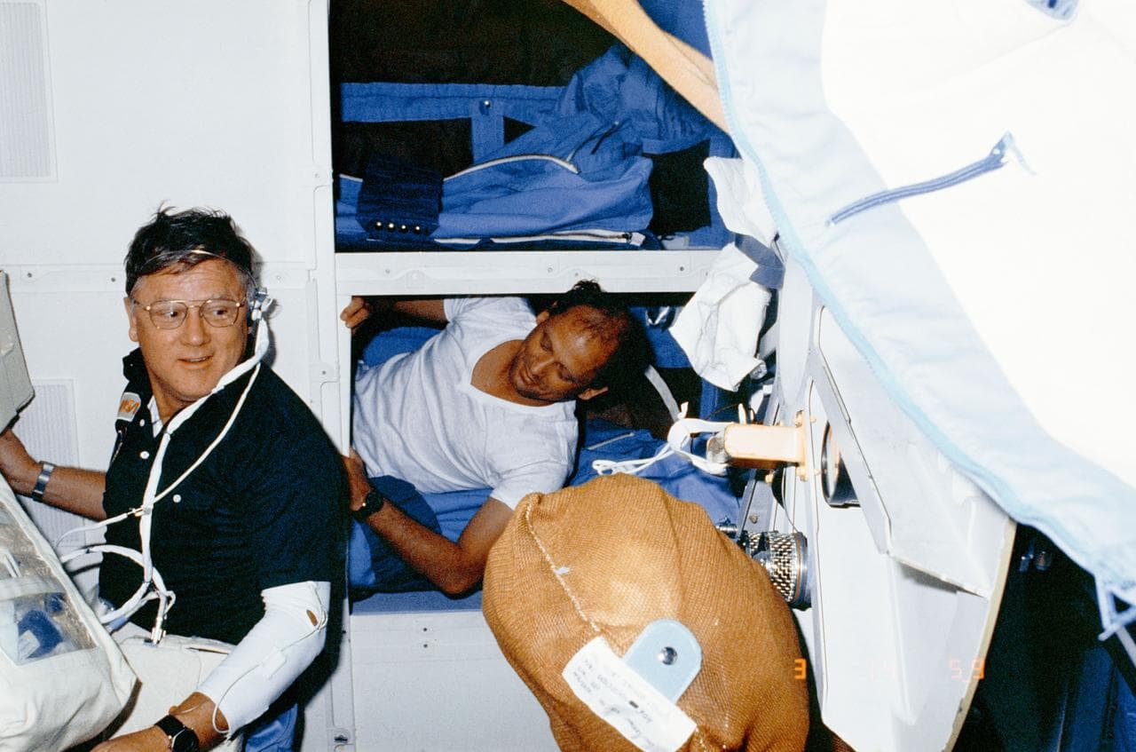Astronaut Norman Thagard rests on middeck while other team is on duty