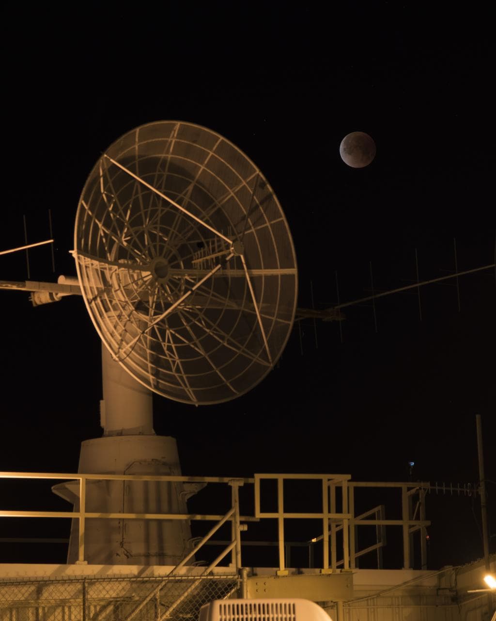 NASA Armstrong Flight Research Center's communications facility with radar dish and the eclipsed moon overhead during Jan. 31 Super Blue Blood Moon.