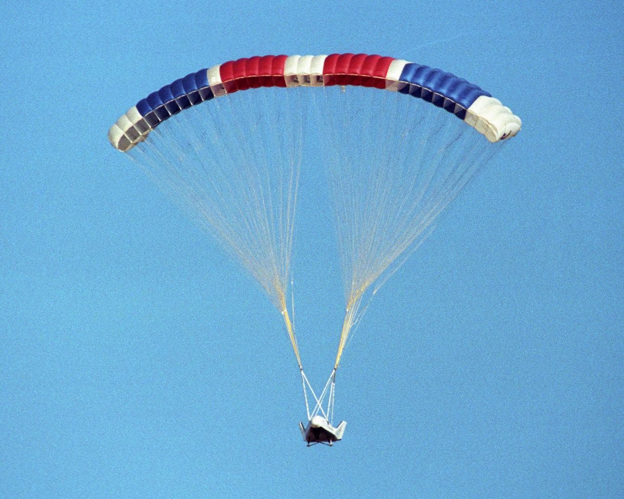 The X-38 prototype of the Crew Return Vehicle is suspended under its giant 7,500-square-foot parafoil during its eighth free flight on Thursday, December 13, 2001