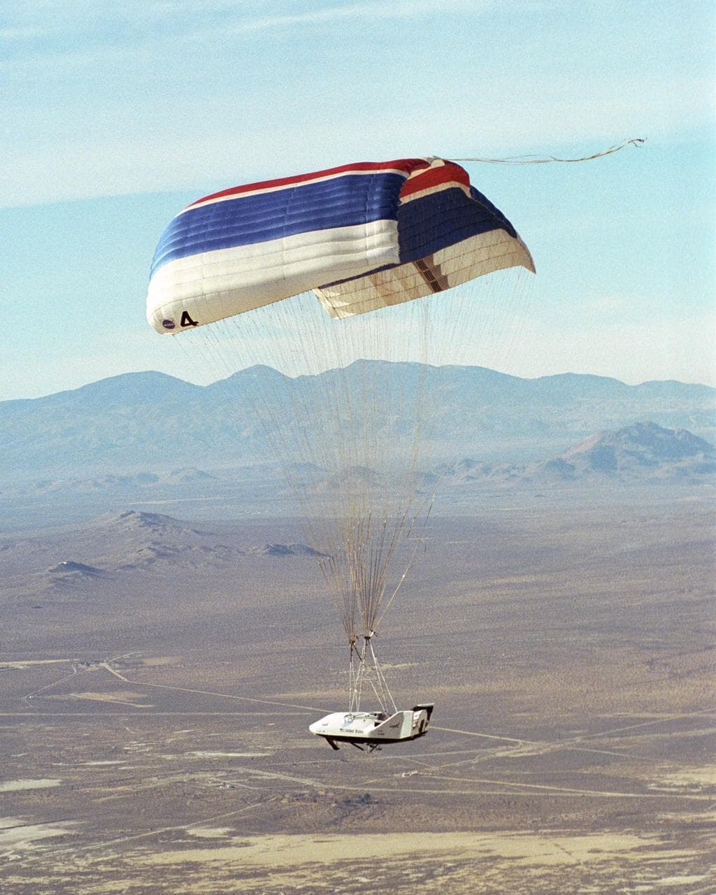 The X-38 prototype of the Crew Return Vehicle is suspended under its giant 7,500-square-foot parafoil during its eighth free flight on Thursday, December 13, 2001