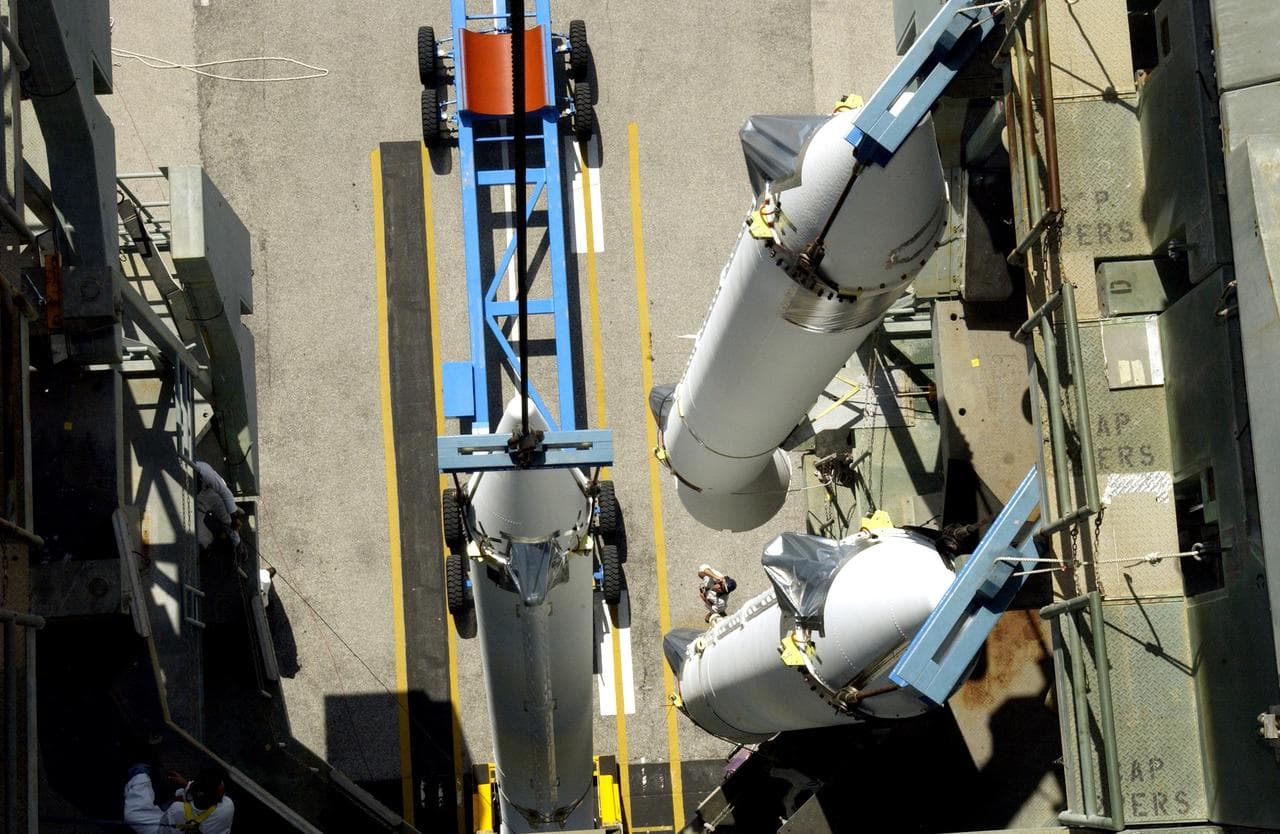 KENNEDY SPACE CENTER, FLA. -   This view from the mobile service tower on Launch Complex 17-B, Cape Canaveral Air Force Station, shows two solid rocket boosters (SRBs) already suspended in the tower while another is being lifted.  They are three of nine  46-inch-diameter, stretched SRBs that are being attached to the Delta II Heavy rocket that will launch the Space Infrared Telescope Facility (SIRTF).  Consisting of three cryogenically cooled science instruments and an 0.85-meter telescope, SIRTF is one of NASA's largest infrared telescopes to be launched.  SIRTF will obtain images and spectra by detecting the infrared energy, or heat, radiated by objects in space. Most of this infrared radiation is blocked by the Earth's atmosphere and cannot be observed from the ground.