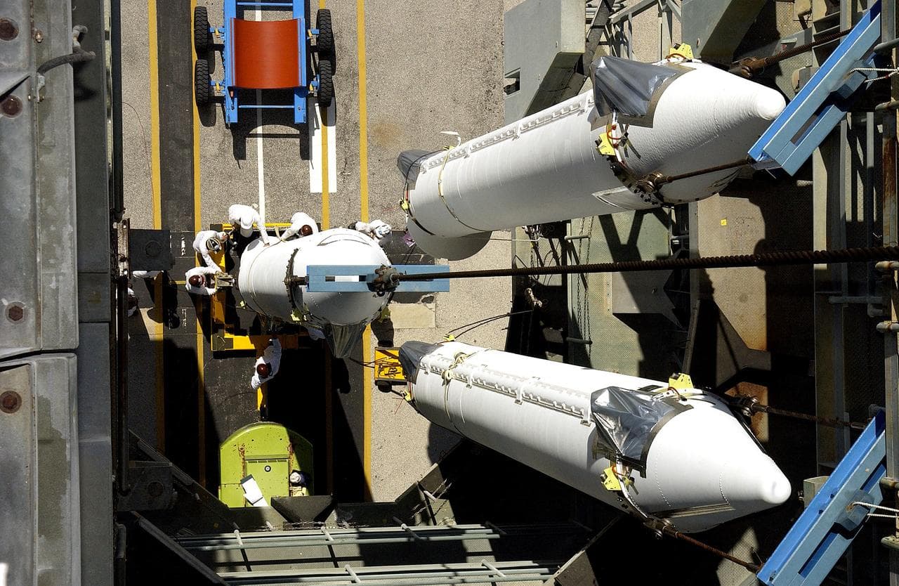 KENNEDY SPACE CENTER, FLA. -   This view from the mobile service tower on Launch Complex 17-B, Cape Canaveral Air Force Station, shows two solid rocket boosters (SRBs) already suspended in the tower while another is being lifted.  They are three of nine  46-inch-diameter, stretched SRBs that are being attached to the Delta II Heavy rocket that will launch the Space Infrared Telescope Facility (SIRTF).  Consisting of three cryogenically cooled science instruments and an 0.85-meter telescope, SIRTF is one of NASA's largest infrared telescopes to be launched.  SIRTF will obtain images and spectra by detecting the infrared energy, or heat, radiated by objects in space. Most of this infrared radiation is blocked by the Earth's atmosphere and cannot be observed from the ground.