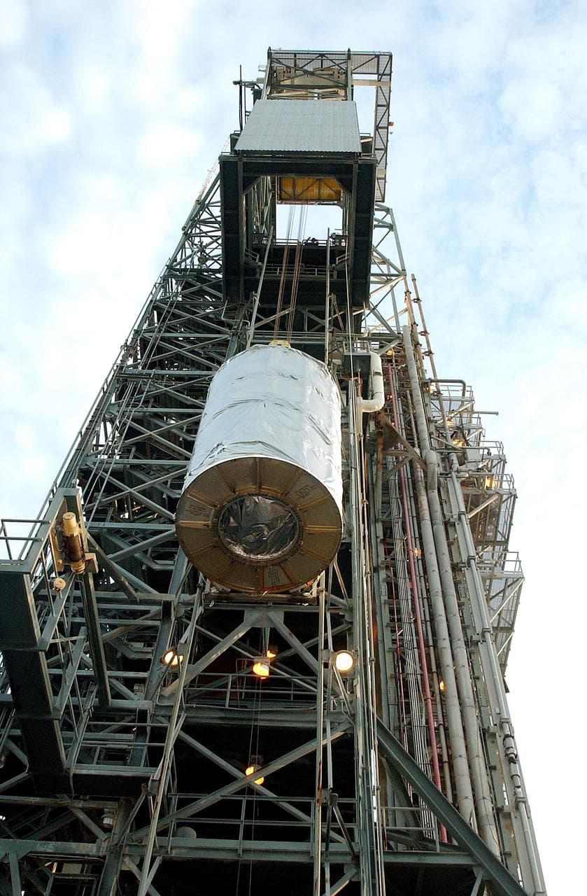 KENNEDY SPACE CENTER, FLA.  -  Viewed from below, the Space Infrared Telescope Facility (SIRTF) is lifted up the mobile service tower on Launch Pad 17-B, Cape Canaveral Air Force Station.  SIRTF will be attached to the Delta II rocket and encapsulated in its fairing before launch.   Consisting of three cryogenically cooled science instruments and an 0.85-meter telescope, SIRTF is one of NASA’s largest infrared telescopes to be launched.  It is the fourth and final element in NASA’s family of orbiting “Great Observatories.”  SIRTF will obtain images and spectra by detecting the infrared energy, or heat, radiated by objects in space. Most of this infrared radiation is blocked by the Earth's atmosphere and cannot be observed from the ground.