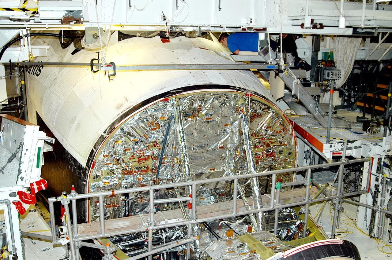 KENNEDY SPACE CENTER, FLA. -  In the Orbiter Processing Facility, United Space Alliance technician Jamie Haynes checks the tiles on the nose of orbiter Atlantis as part of return-to-flight activities.  Atlantis is scheduled for mission STS-114, a return-to-flight test mission to the International Space Station.
