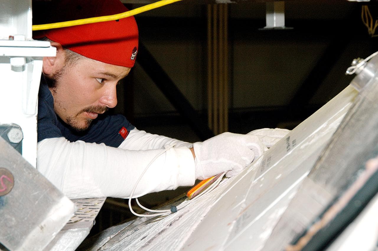 KENNEDY SPACE CENTER, FLA. - In the Orbiter Processing Facility, United Space Alliance technician Chris Moore performs gap tests on the tiles of the nose of orbiter Atlantis as part of return-to-flight activities.  Atlantis is scheduled for mission STS-114, a return-to-flight test mission to the International Space Station.
