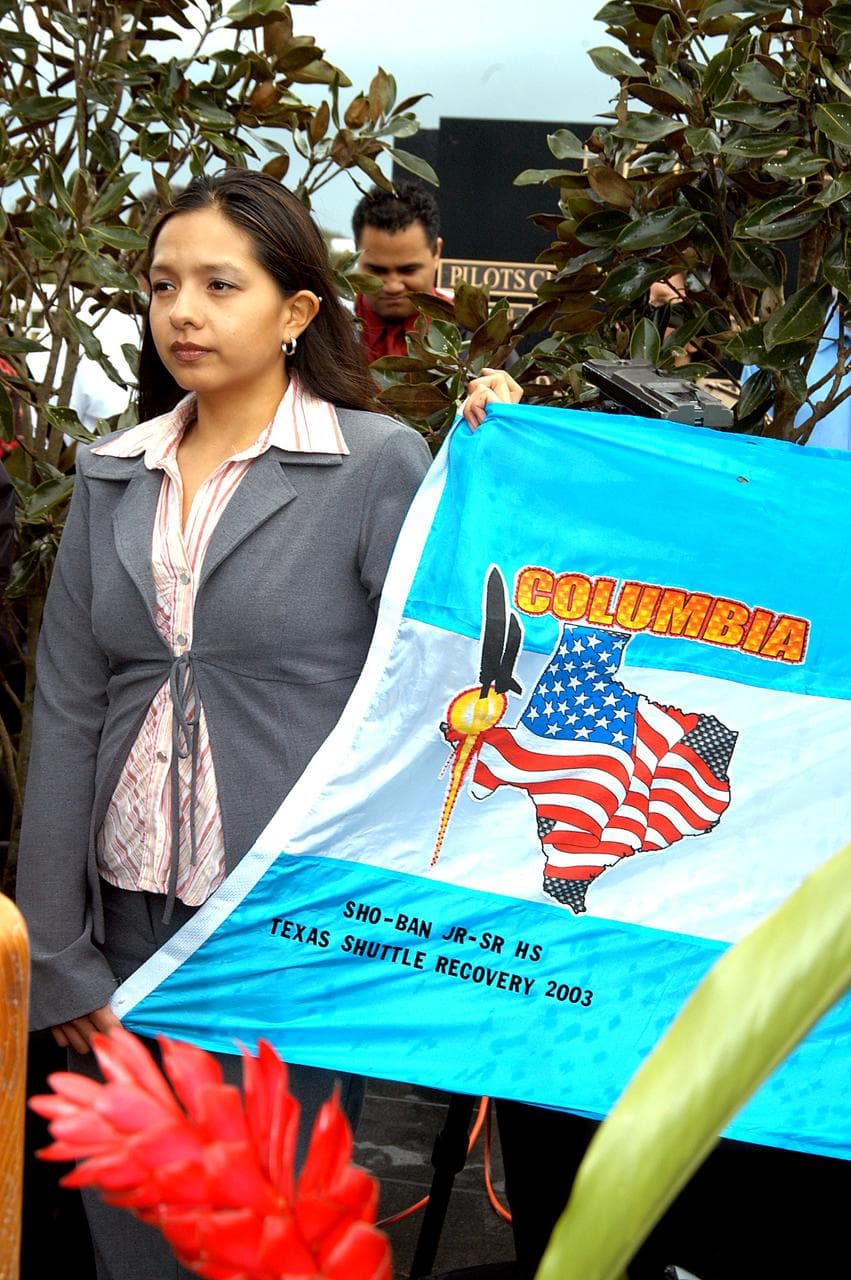 KENNEDY SPACE CENTER, FLA. - A student from Shoshone-Bannock Junior-Senior High School, Fort Hall, Idaho, holds part of a flag presented by dancers from the Shoshone-Bannock Native American community, Fort Hall, Idaho, commemorating the orbiter Columbia and her crew.  The dancers performed a healing ceremony during the memorial service held at the Space Memorial Mirror for the crew of Columbia.  Feb. 1 is the one-year anniversary of the loss of the crew and orbiter Columbia in a tragic accident as the ship returned to Earth following mission STS-107.  Students and staff of the Shoshone-Bannock Nation had an experiment on board Columbia. The public was invited to the memorial service, held in the KSC Visitor Complex, which included comments by Center Director Jim Kennedy and Executive Director of Florida Space Authority Winston Scott.  Scott is a former astronaut who flew on Columbia in 1997.