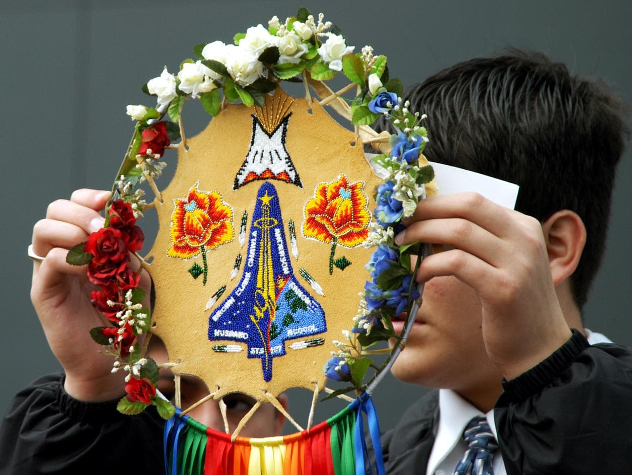 KENNEDY SPACE CENTER, FLA. - A member of the Shoshone-Bannock Native American community from Fort Hall, Idaho, displays a handmade item with the STS-107 logo.  Dancers from Shoshone-Bannock Junior-Senior High School performed a healing ceremony during the memorial held at the Space Memorial Mirror, in the KSC Visitor Complex.  Feb. 1 is the one-year anniversary of the loss of the crew and orbiter Columbia in a tragic accident as the ship returned to Earth following mission STS-107.  Students and staff of the Shoshone-Bannock Nation had an experiment on board Columbia. The public was invited to the memorial service, held in the KSC Visitor Complex, which included comments by Center Director Jim Kennedy and Executive Director of Florida Space Authority Winston Scott.  Scott is a former astronaut who flew on Columbia in 1997.