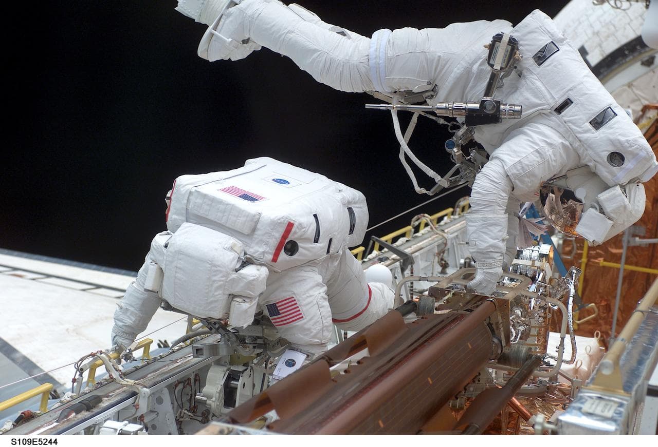 STS-109 MS Grunsfeld and Linnehan stow old solar array from payload bay