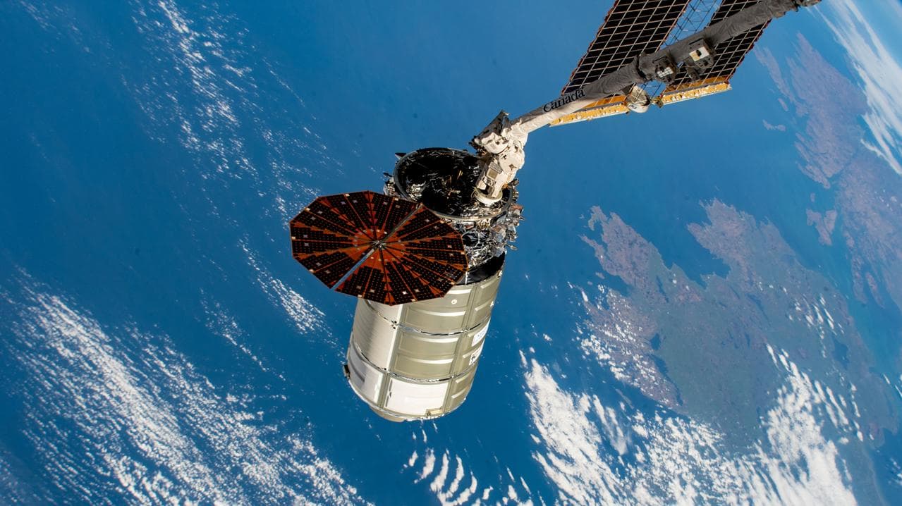 The Cygnus space freighter in the grip of the Canadarm2 robotic arm