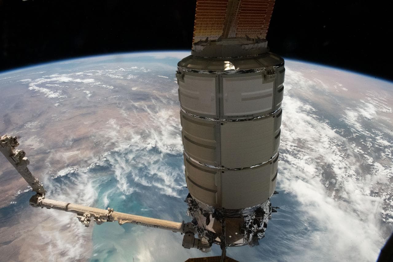 The Cygnus space freighter in the grip of the Canadarm2 robotic arm