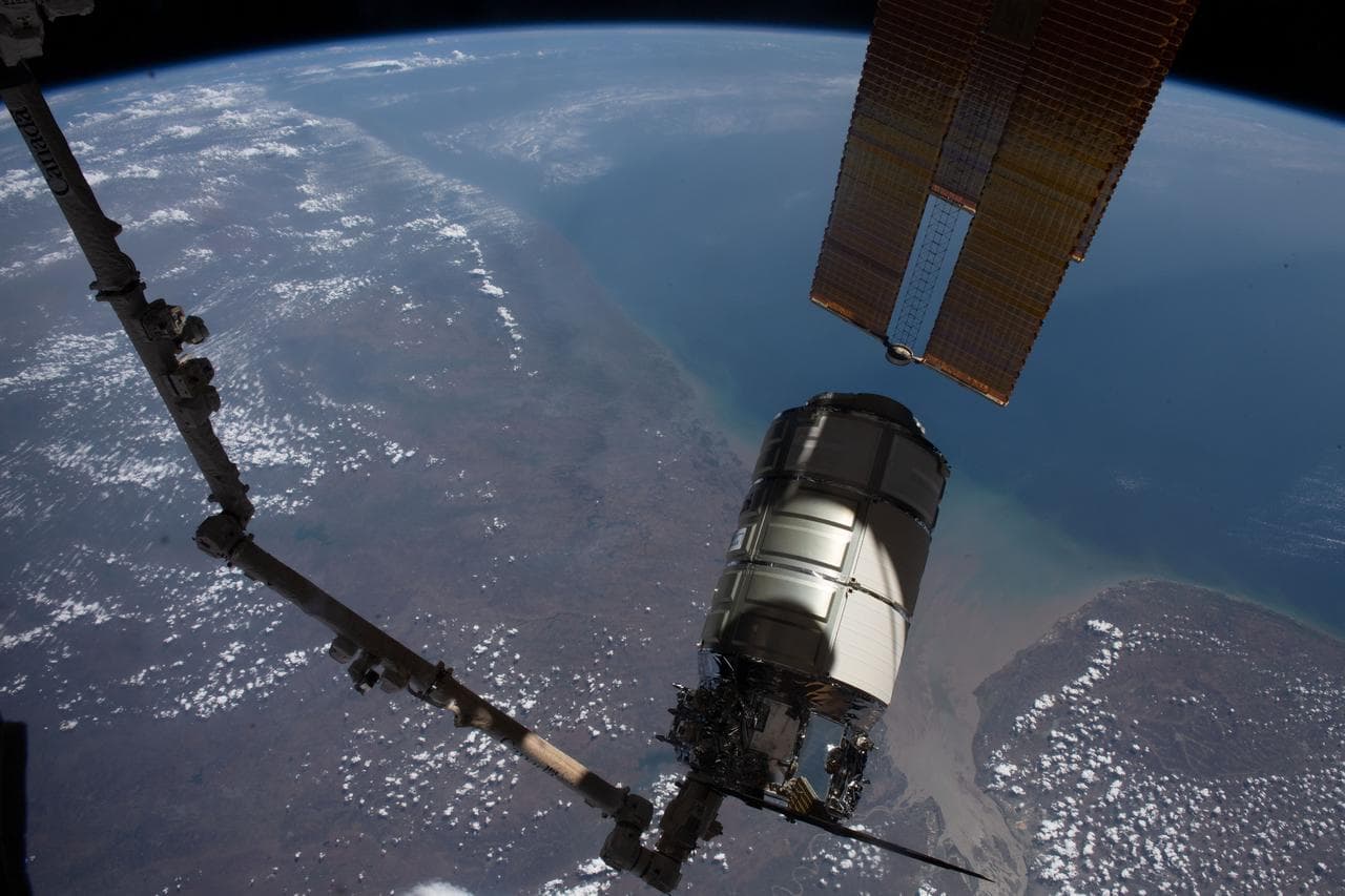 The Cygnus space freighter in the grip of the Canadarm2 robotic arm