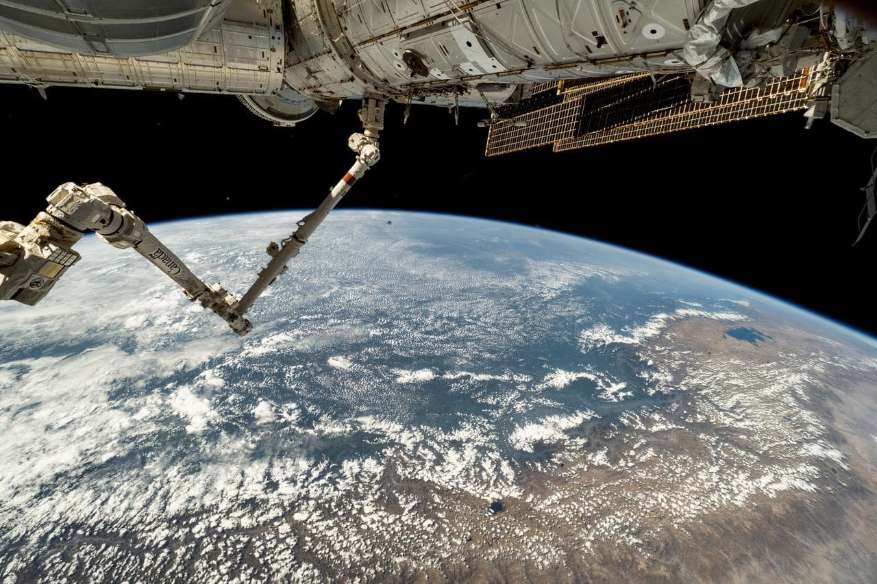 The 57.7-foot-long Canadarm2 robotic arm extends from the International Space Station