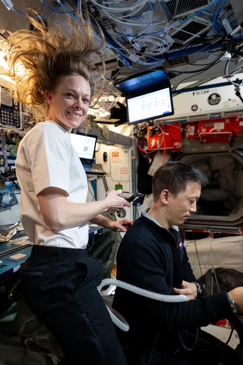 Nichole Ayers trims Jonny Kim's hair aboard the International Space Station