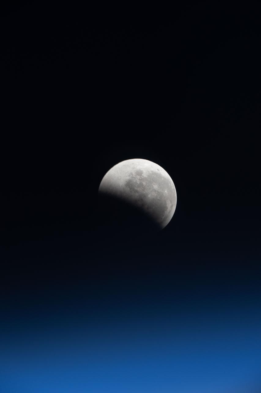 The lunar eclipse, also known as the Blood Moon, above Earth's horizon