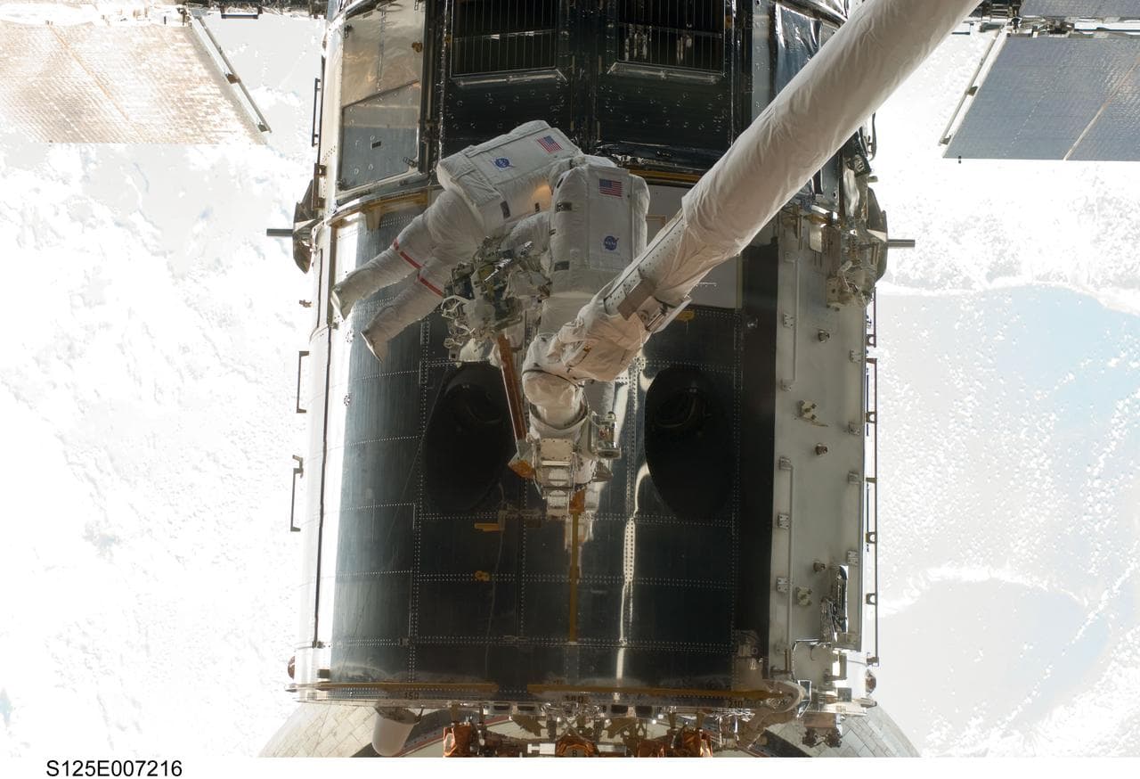 STS-125 MS5 Feustel and MS3 Grunsfeld during EVA1