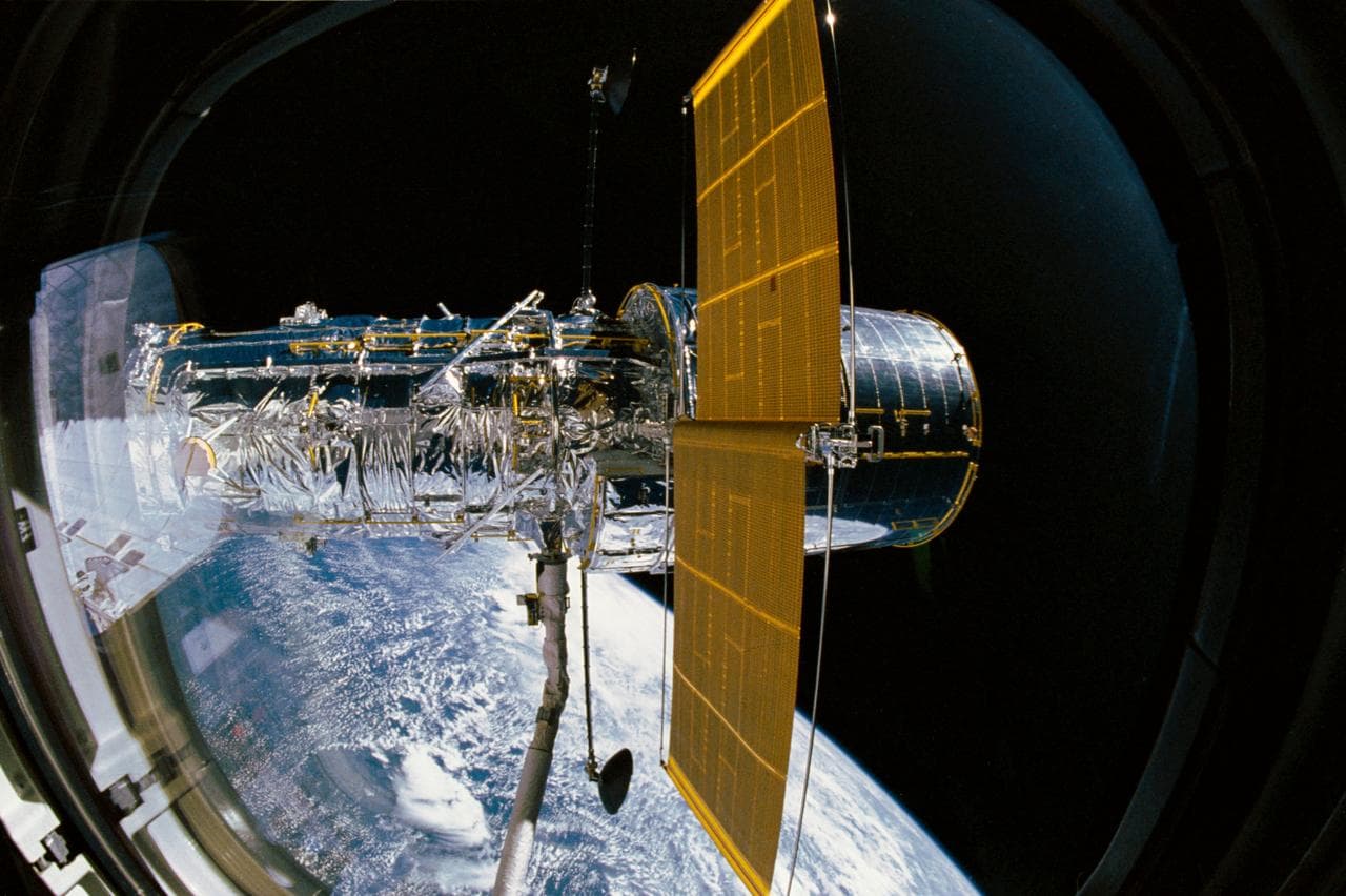 STS-31 Hubble Space Telescope (HST) (SAs & HGAs deployed) is grappled by RMS