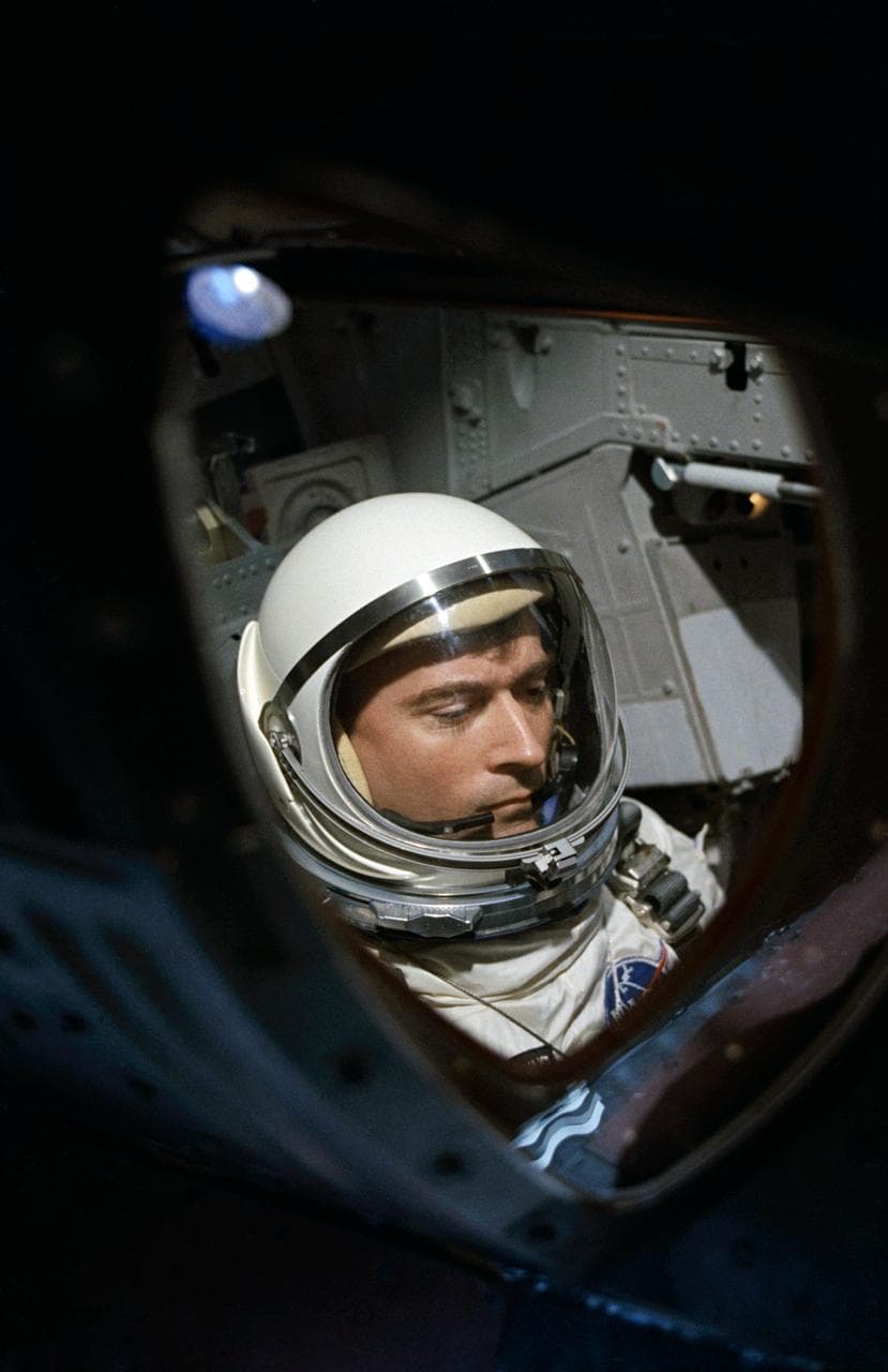 View of Astronaut John Young through spacecraft window prior to launch