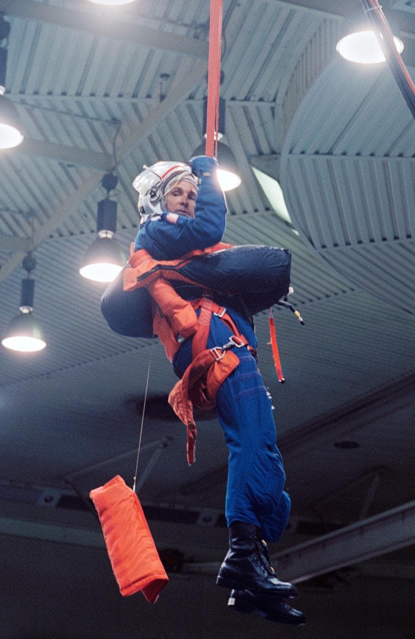 Astronaut Curtis Brown suspended by simulated parachute gear during training