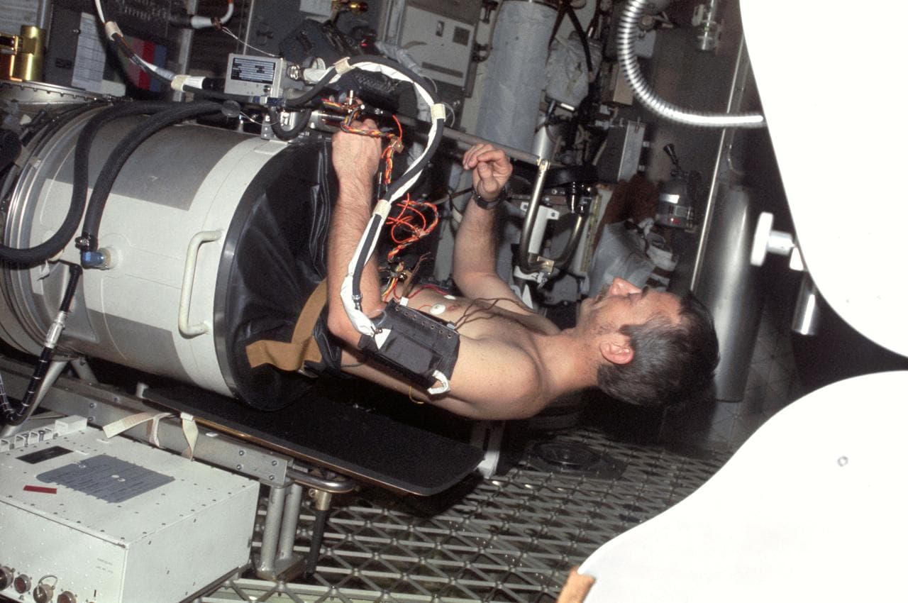 Astronaut Owen Garriott lies in Lower Body Negative Pressure Device