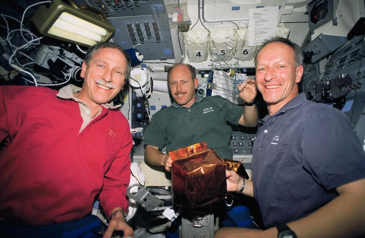 STS-61 crewmembers prepare covers for magnetometers on HST