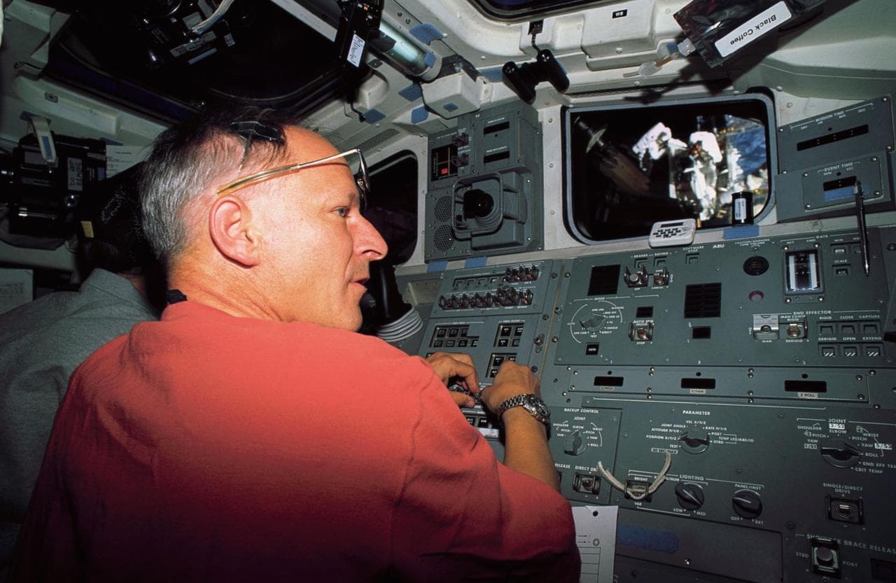 Astronaut Claude Nicollier on flight deck at controls of the RMS