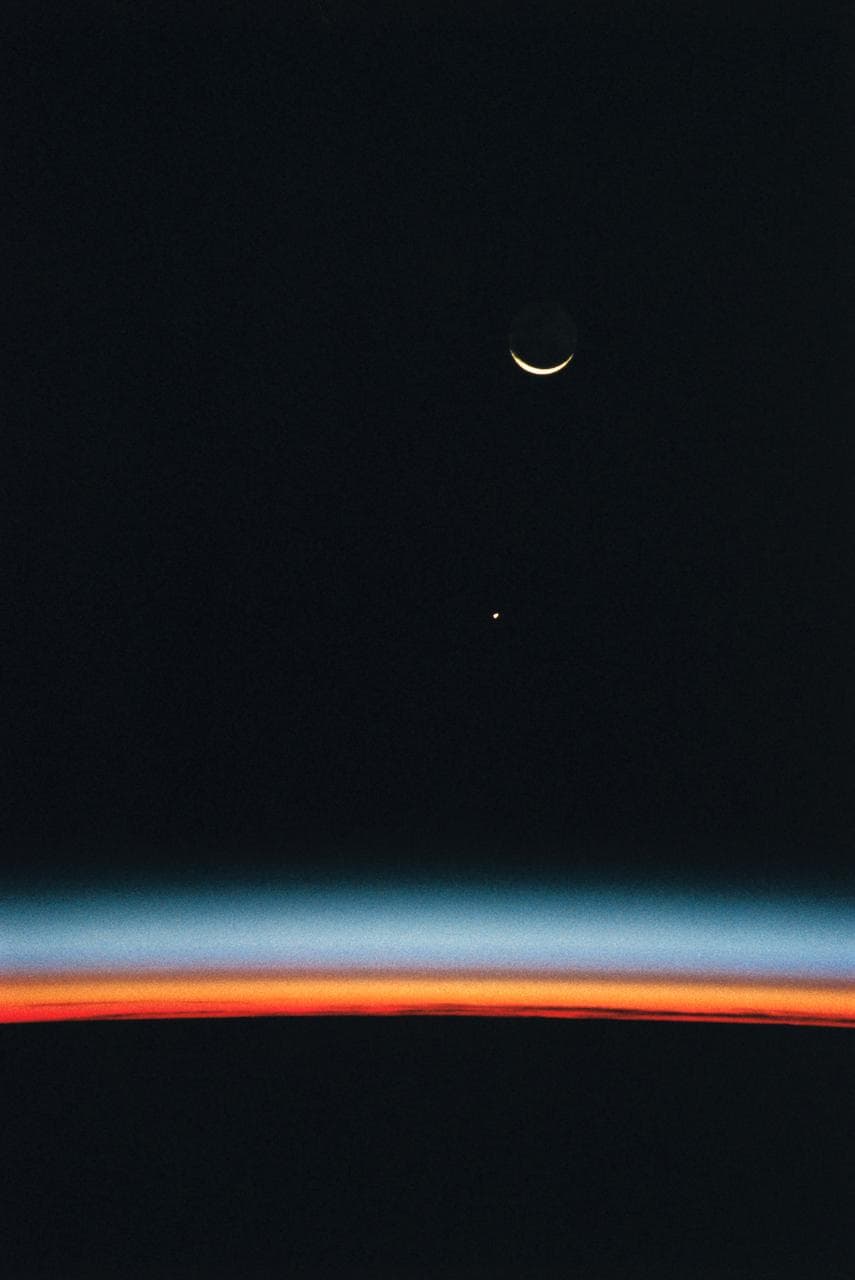 Earth-orbiting HST, airglow over Earth's horizon, and crescent moon