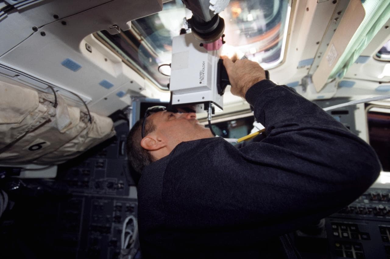 STS-109 MS Linnehan on aft flight deck with laser rangefinder